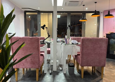 Interior of Blush and Buff, Cape Town, with pink chairs, modern decor, and elegant lighting.
