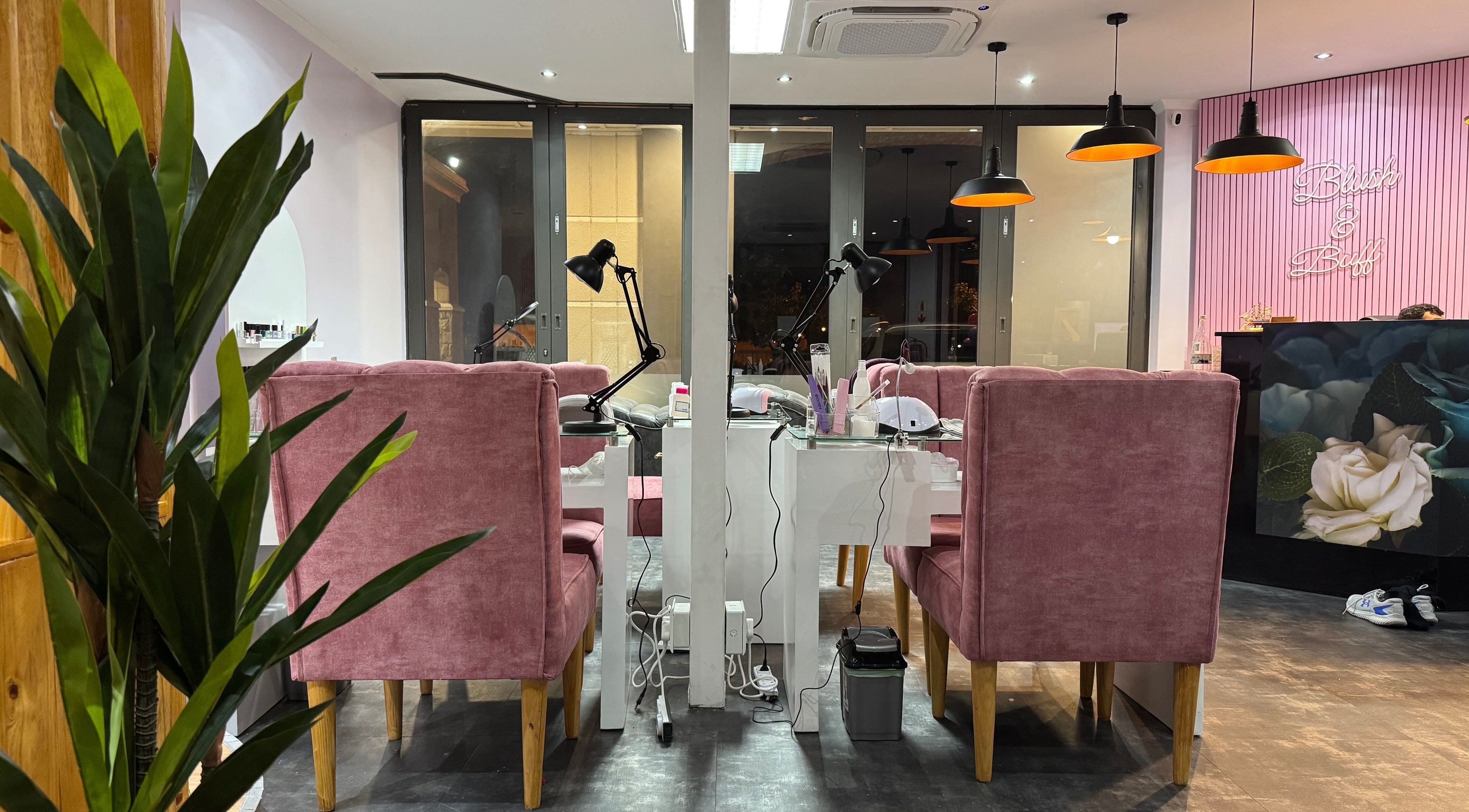 Elegant salon setup at Blush and Buff in Cape Town, Western Cape, ZA with pink seating and modern decor.