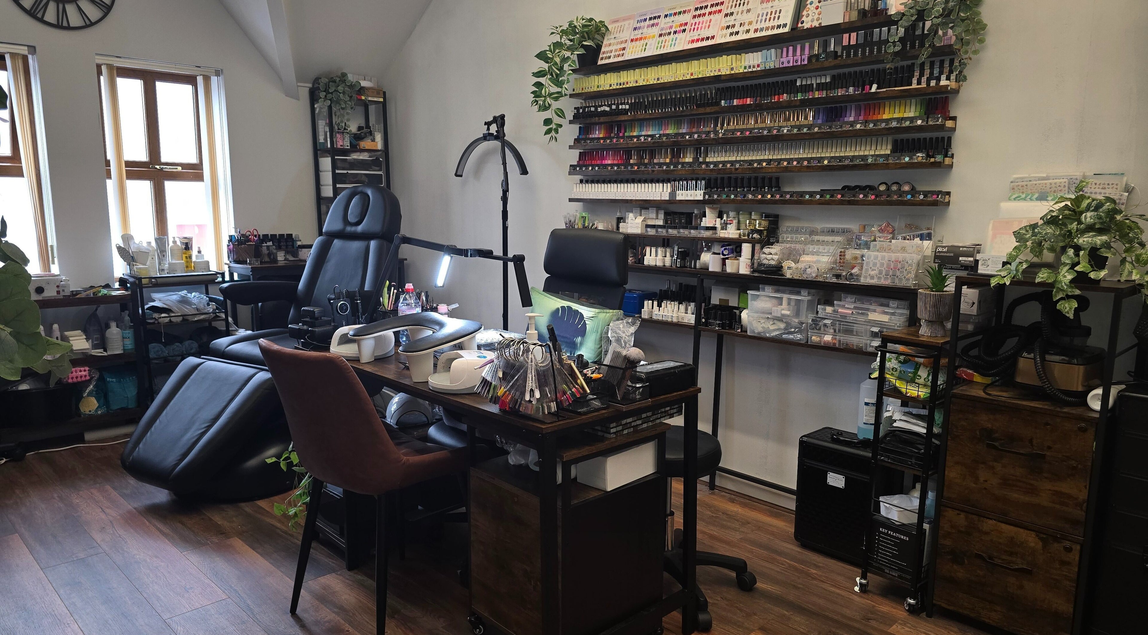 Spacious nail salon at Kalos & Grace, Ballymoney, Northern Ireland, GB featuring modern chairs and nail polish racks.