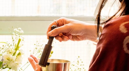 Hands using a mortar at Balance and Bloom Ayurveda at The Float Spa, Brighton And Hove, England, GB.