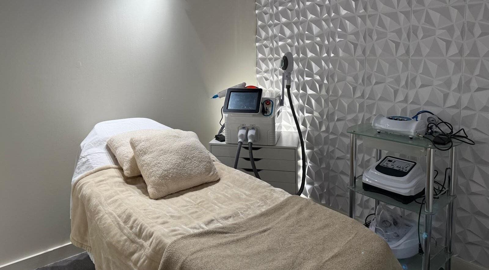 Relaxing treatment room at Nua Med Spa, Hialeah, Florida, US with a cozy massage bed and modern equipment.