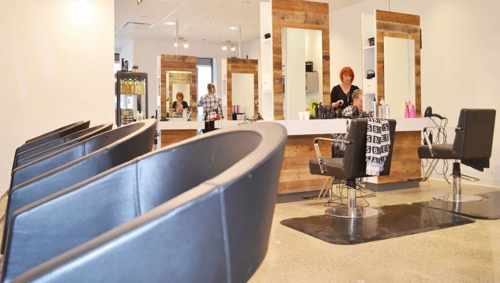 Intérieur moderne du salon American Style Coiffure à Laval, Québec, CA, avec sièges et miroir élégant.