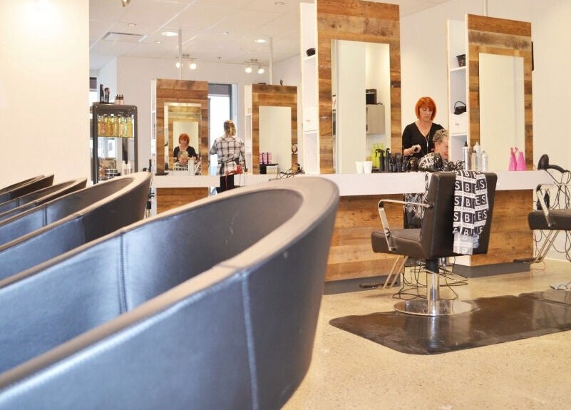 Intérieur moderne du salon American Style Coiffure à Laval, Québec, CA, avec sièges et miroir élégant.