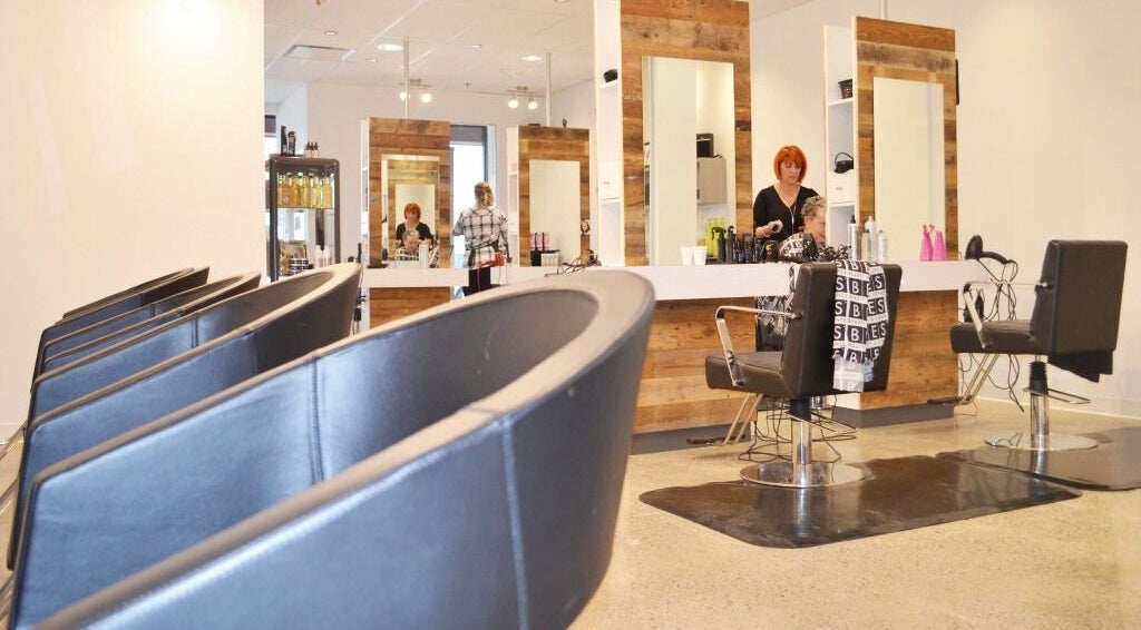Intérieur moderne du salon American Style Coiffure à Laval, Québec, CA, avec sièges et miroir élégant.