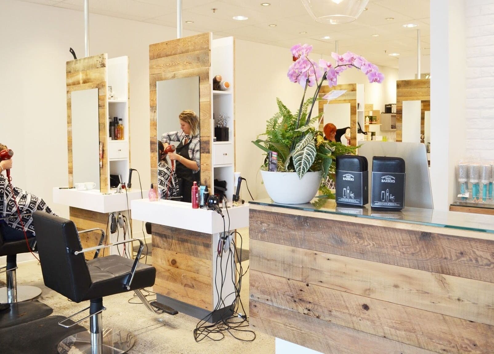 Intérieur élégant de American Style Coiffure à Laval, Québec, CA, avec des stations de coiffure en bois.