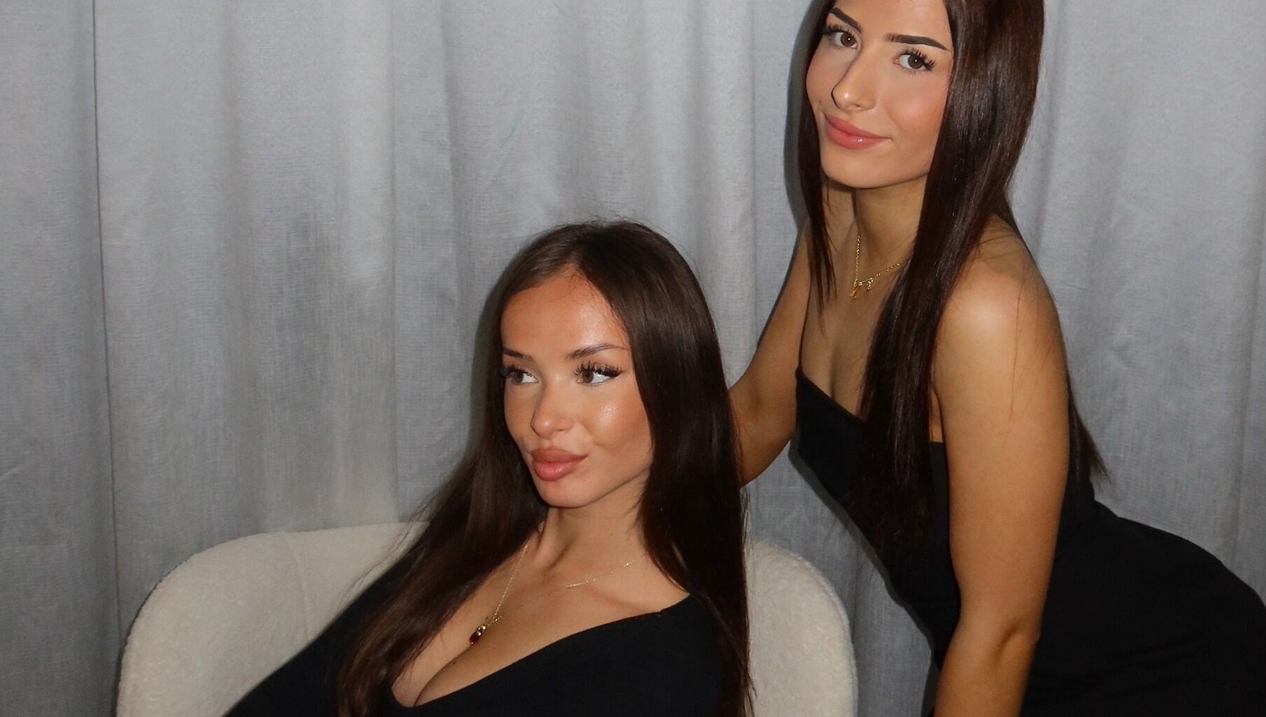 Two women in elegant black outfits posing at Modify Beauty Bar, Melbourne, Victoria, AU.