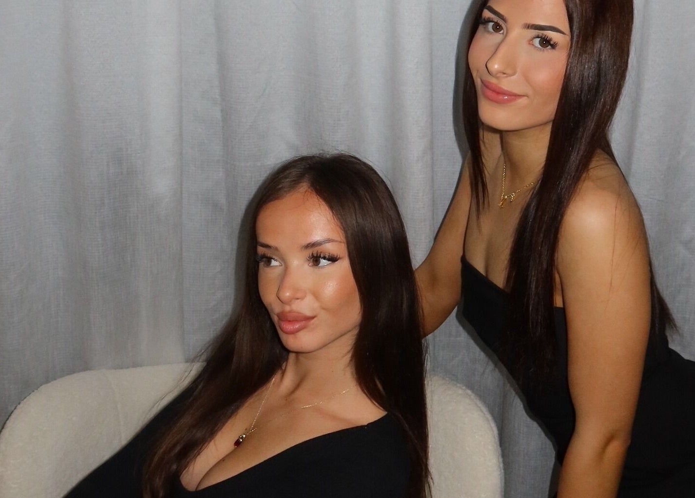 Two women in elegant black outfits posing at Modify Beauty Bar, Melbourne, Victoria, AU.