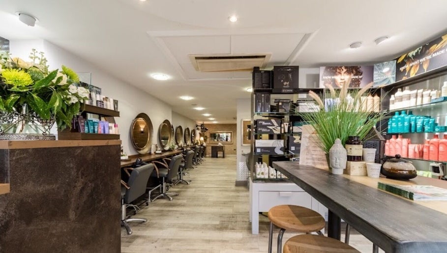 Elegant salon interior at The Nik Effect in Birmingham, England, GB showcasing styling stations and product displays.