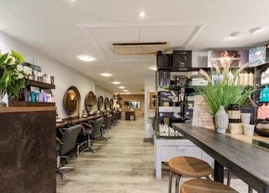 Elegant salon interior at The Nik Effect in Birmingham, England, GB showcasing styling stations and product displays.