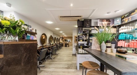 Elegant salon interior at The Nik Effect in Birmingham, England, GB showcasing styling stations and product displays.