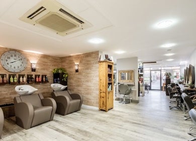 Chic interiors of The Nik Effect salon in Birmingham, England, GB showcasing modern styling stations.