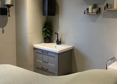 Relaxing treatment room at The Nik Effect, Birmingham, England, GB featuring soothing decor and a sink.