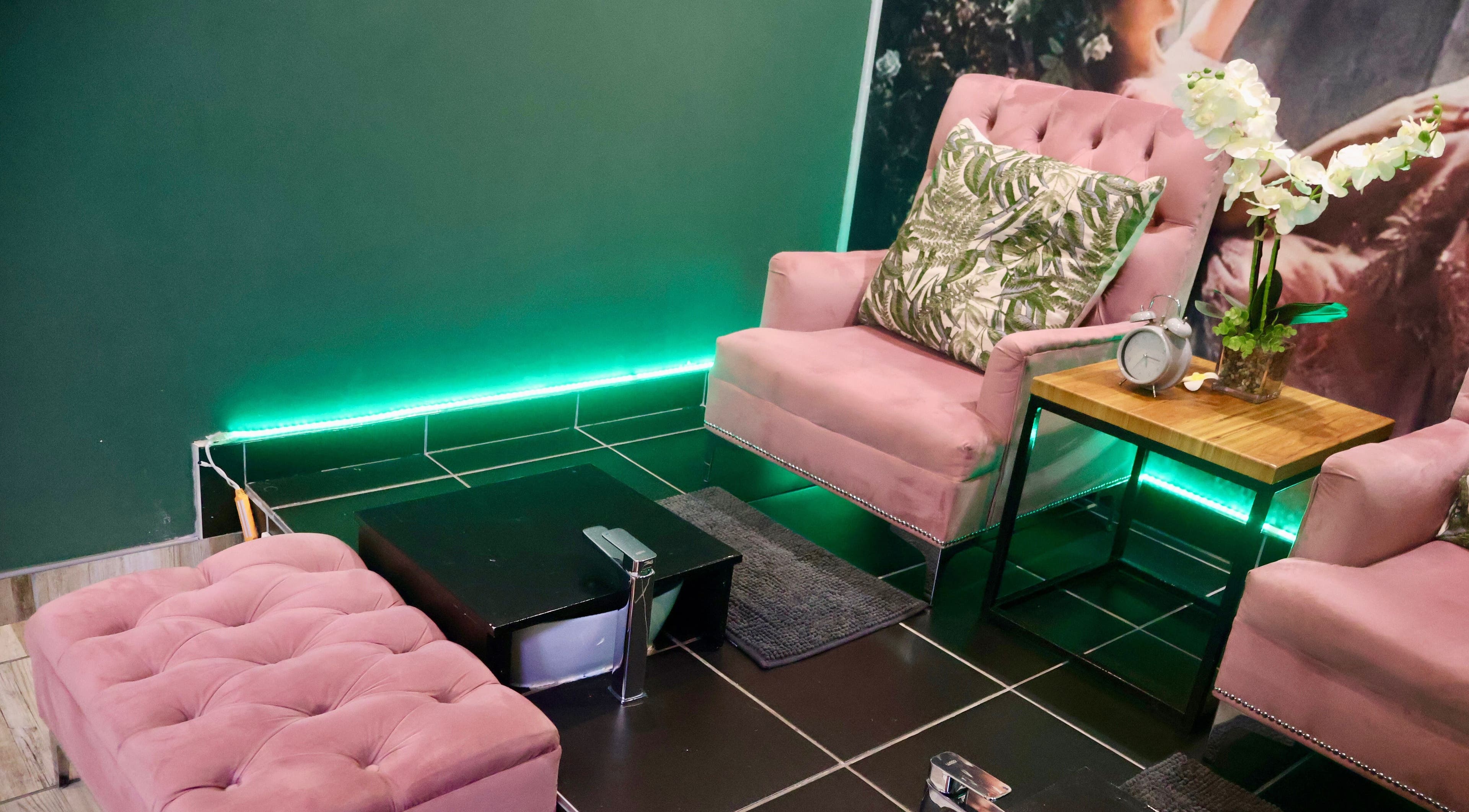 Elegant seating area at Ayla Glow Bar, Boksburg, Gauteng, ZA with pink chairs and a green backdrop.