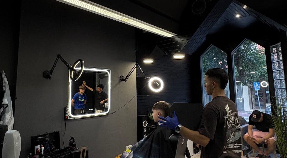 Interior moderno de Cuts, Tudela, Navarra, ES, mostrando una barbería en acción.