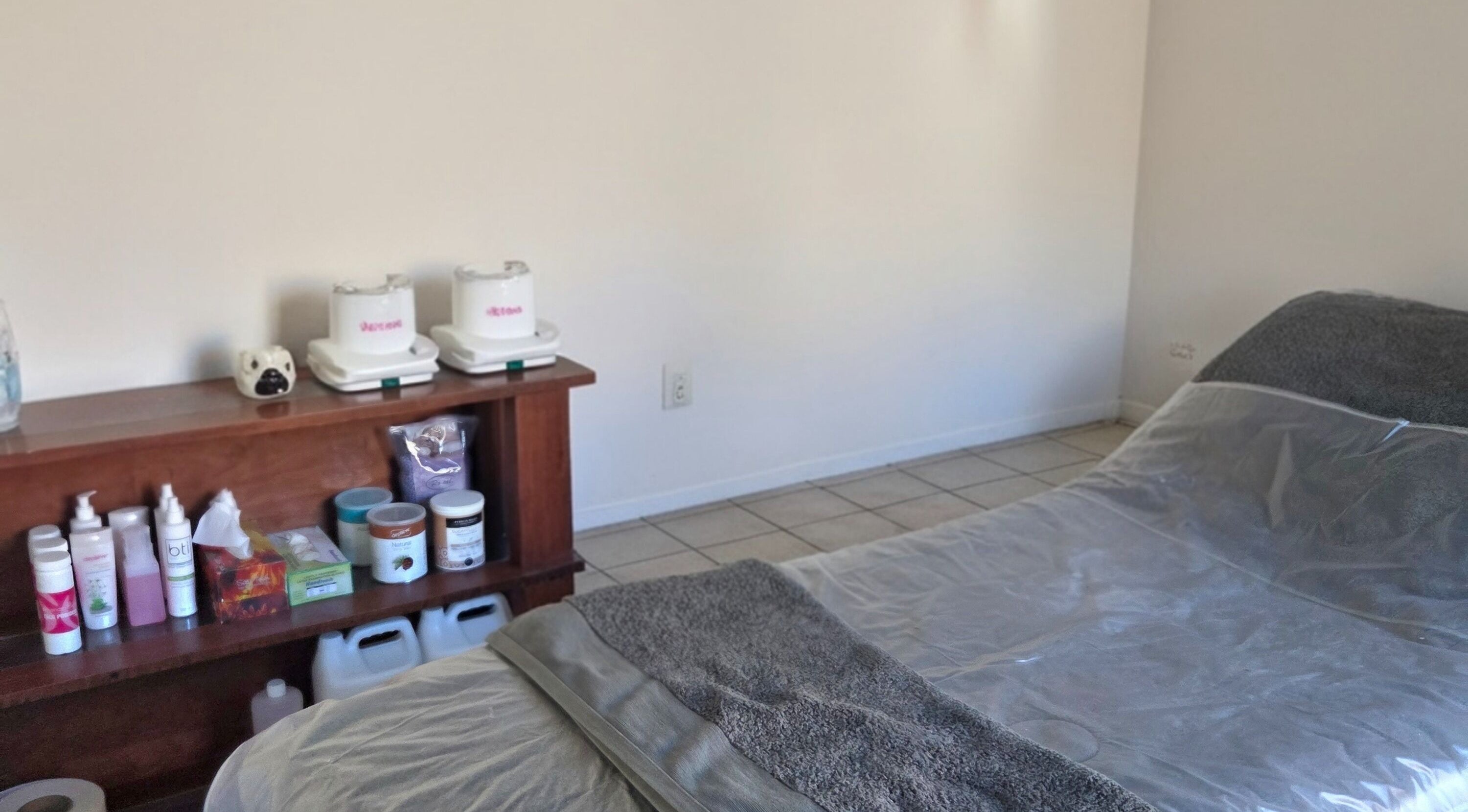 Cozy treatment room at Sugar in Cape Town, Western Cape, ZA with products neatly displayed on shelves.