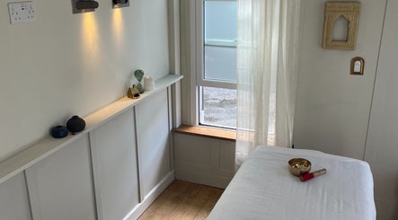 Tranquil massage room at FOLK, Perranporth, England, GB with soft lighting and peaceful decor.