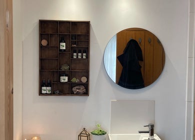 Stylish wellness space at FOLK, Perranporth, England, GB with wooden shelves, mirror, and natural products.