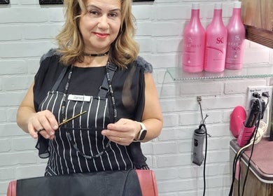 Jane hairstylist smiling with tools in Hamilton, Ontario, CA hair salon.
