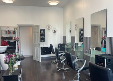 Elegant salon chairs and mirrors at hairbyrosie, Lydney, England, GB highlighting a stylish beauty experience.