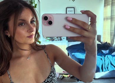 Woman taking a selfie at hairbyrosie in Lydney, England, GB with styled hair and pink nails.
