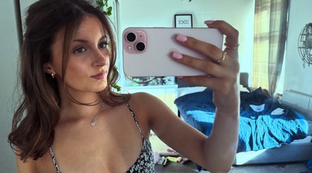 Woman taking a selfie at hairbyrosie in Lydney, England, GB with styled hair and pink nails.