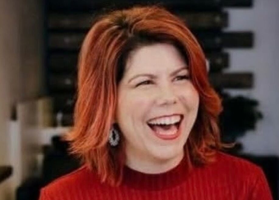 Smiling person with vibrant red hair at Hair by Greshan, Edgecliff, New South Wales, AU.