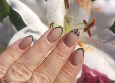 Elegant black-tipped nails with floral backdrop at EverLuxe Nails, Bilston, Scotland, GB.
