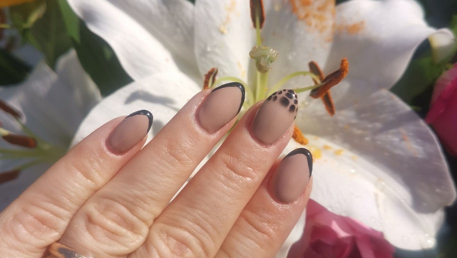 Elegant black-edged nails with floral backdrop at Ever Luxe Nails, Bilston, Scotland, GB.