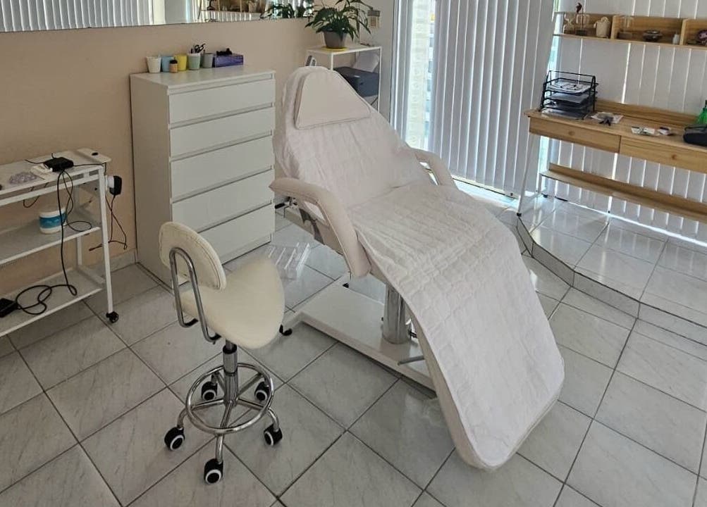 Εσωτερικό χώρου Art Touch στην Ηλιούπολη, GR με κρεβάτι θεραπείας και καρέκλα.