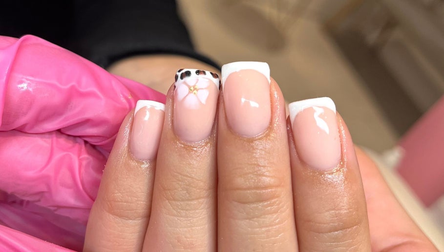 Chic French manicure with floral detail at Glossy Nails, Pontypridd, Wales, GB.