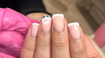 Chic French manicure with floral detail at Glossy Nails, Pontypridd, Wales, GB.