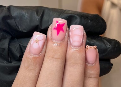 Pink star nail art at Glossy Nails in Pontypridd, Wales, GB. Trendy designs on manicured nails.