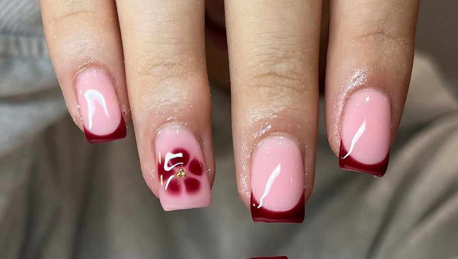 Stylish pink and red nail art at Glossy Nails, Pontypridd, Wales, GB. Perfectly manicured hands showcasing elegance.