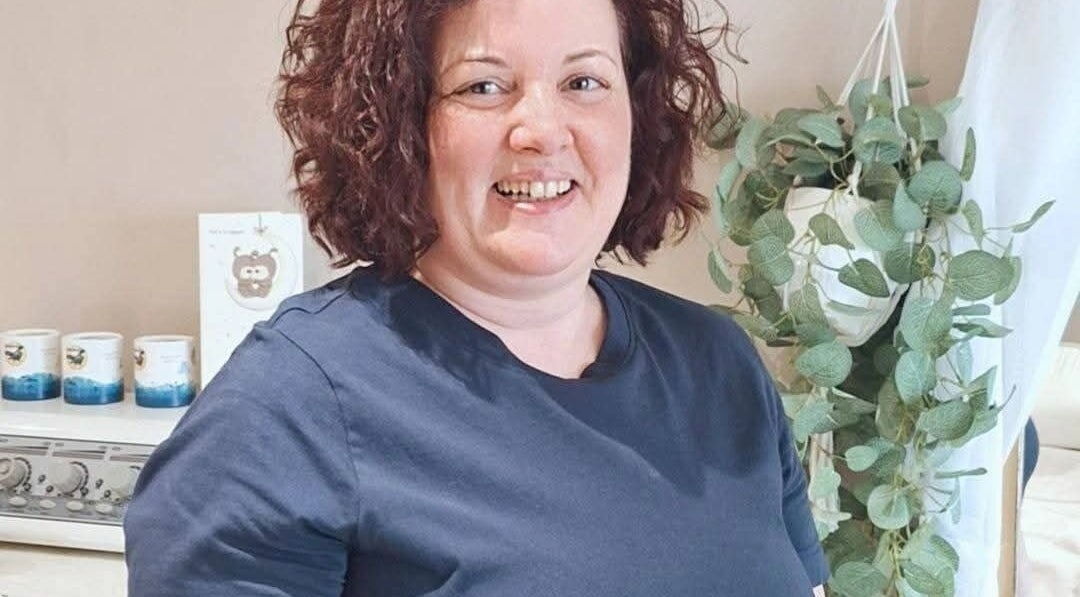 Therapist at Elara Holistic Therapies, Rutherglen, Scotland. Cozy interior with plants.