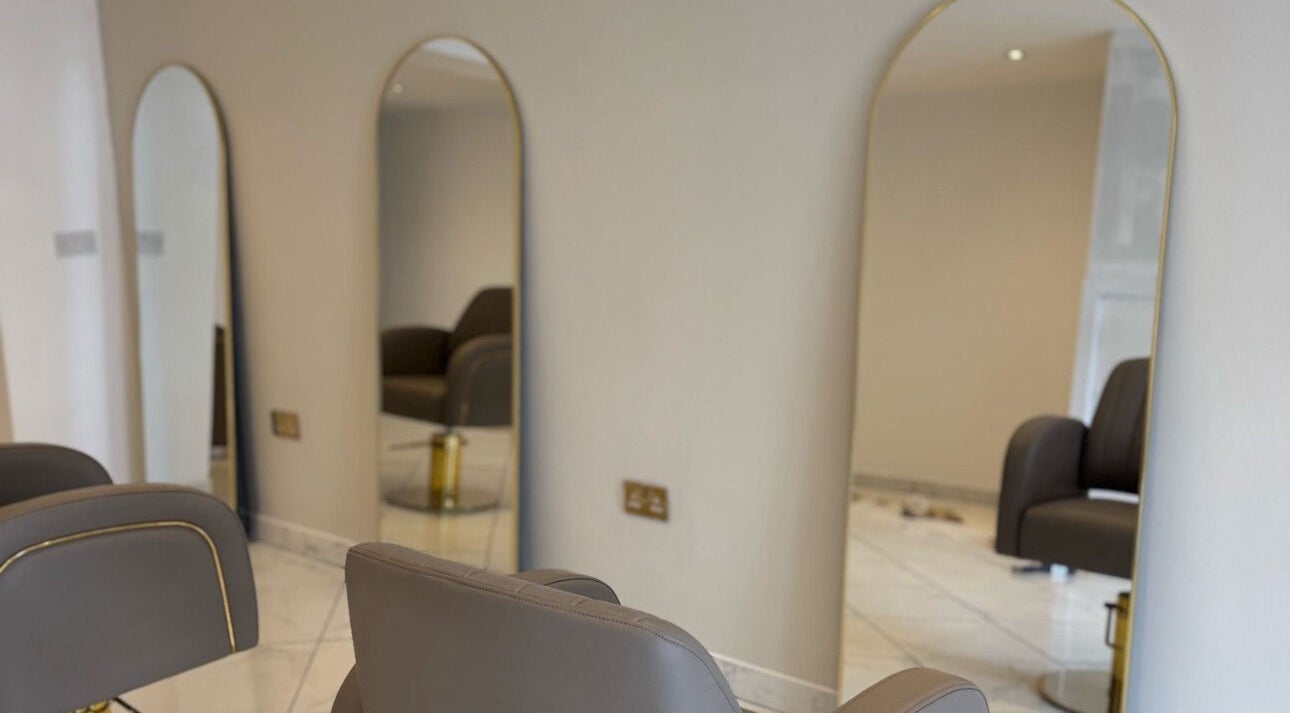 Stylish salon interior at The Hair Lounge, Norwich, England, GB, featuring modern mirrors and chairs.