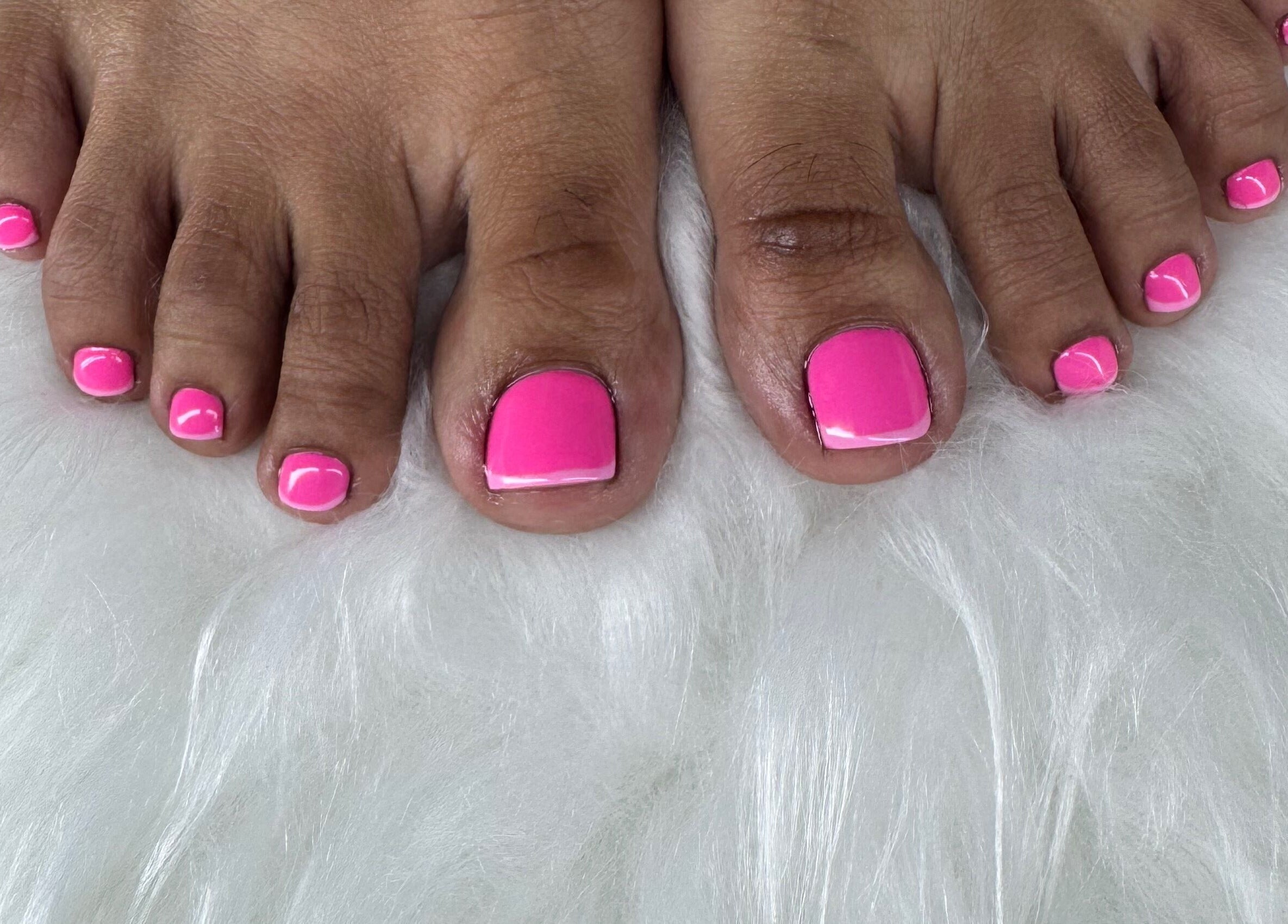 Vibrant pink pedicure on fluffy rug at Chrissy Aestheticss, Bridgetown, Saint Michael, BB.