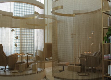 مقاعد فاخرة في Reset Salon، الخبر، المنطقة الشرقية، SA، وسط أجواء هادئة وسلسلة من الستائر الذهبية.