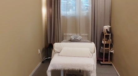 Cozy treatment room at Biomechanic Jana, Београд, RS. Features a massage bed and soothing decor.