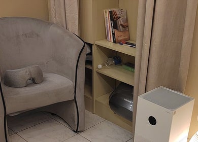 Relaxation nook with chair and books at Biomechanic Jana, Београд, RS, perfect for unwinding and wellness.