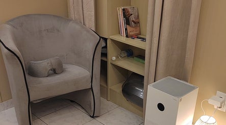 Relaxation nook with chair and books at Biomechanic Jana, Београд, RS, perfect for unwinding and wellness.