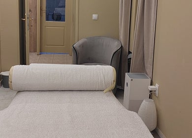 Interior of Biomechanic Jana in Београд, RS, featuring a massage bed and chair in a serene setting.
