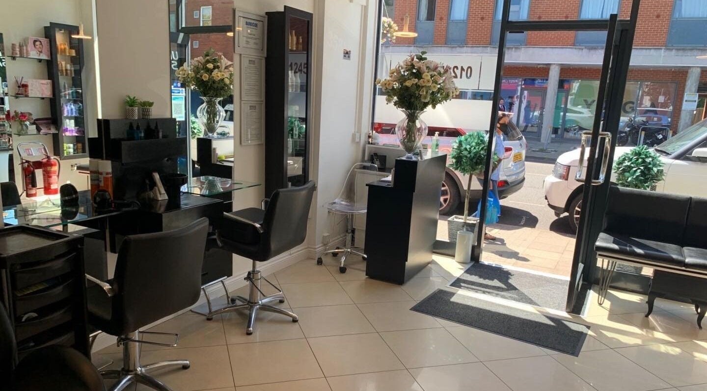 GENESIS HAIRDRESSING & BARBERS salon interior in Chelmsford, England, GB showcases elegant styling stations and decor.