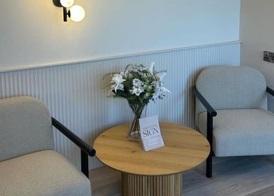 Cozy lounge at Pause Beauty & Holistic, Chew Magna, England, with floral decor and soft lighting.