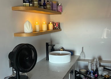 Calming corner at Pause Beauty & Holistic, Chew Magna, England, featuring shelves and lit candles.