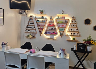 Nail polish display and manicure station at Nominnie Beauty, Bloemfontein, Free State, ZA. Modern and inviting space.