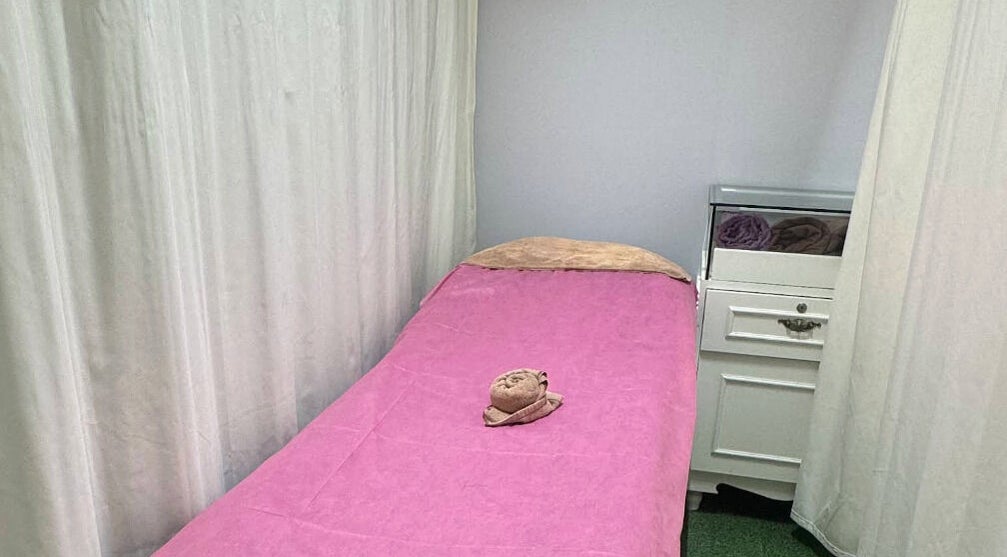 Cozy treatment room at Riviea Beauty Salon, Wan Chai, Hong Kong Island, HK, with pink linen and towel.