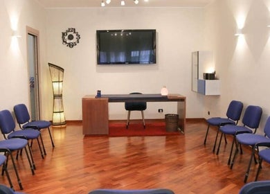 Interno di una sala riunioni a Centro Olistico Cribes, Roma, Lazio, IT con sedie blu e scrivania.