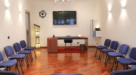 Interno di una sala riunioni a Centro Olistico Cribes, Roma, Lazio, IT con sedie blu e scrivania.