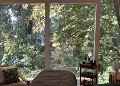 Serene facial therapy room at SlowSkin Facials in London, England, GB with lush green view.