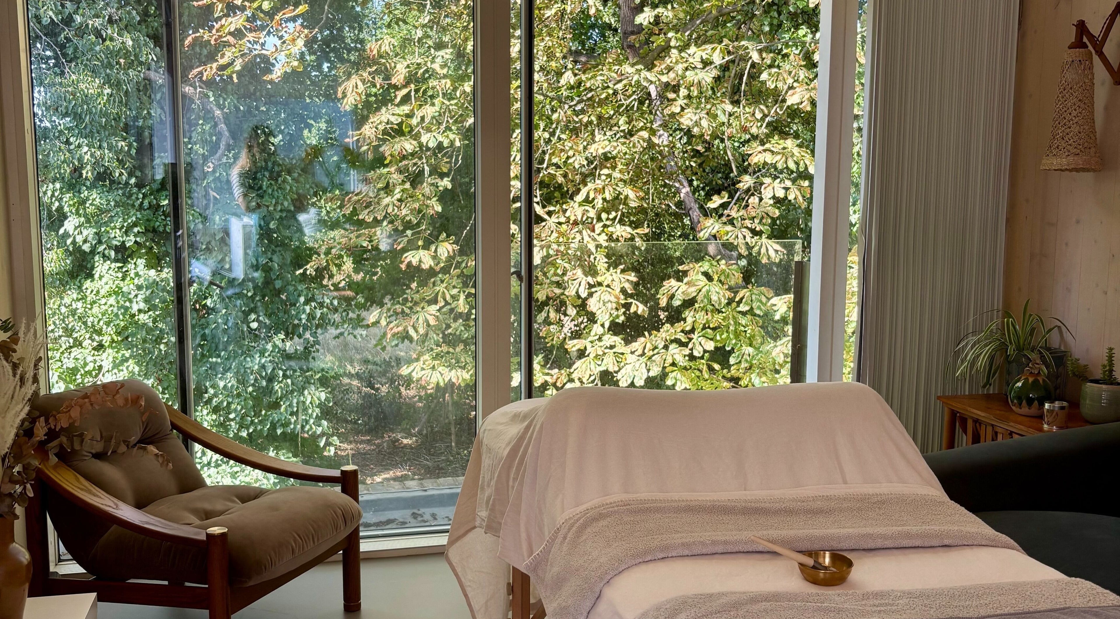 Peaceful treatment room at SlowSkin Facials, London, England, GB with a lush outdoor view.